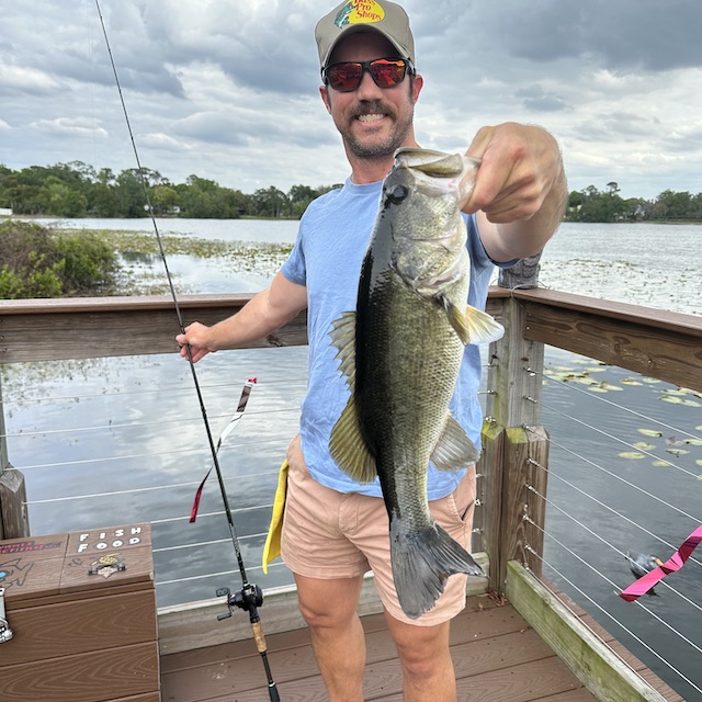 Bucky Schwarz on a dock holding a photogenic largemouth bass
